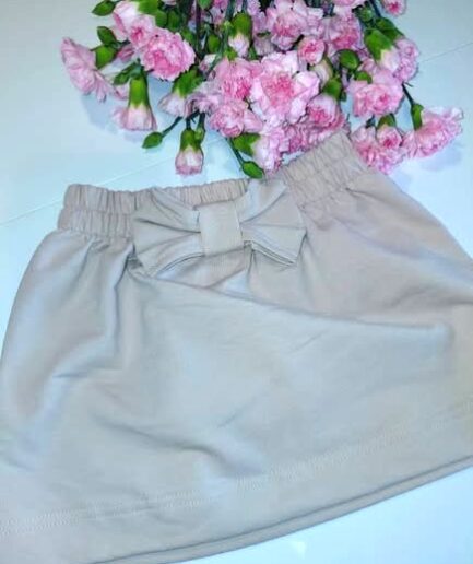 Spódniczka beżowa z kokardą w tle goździki