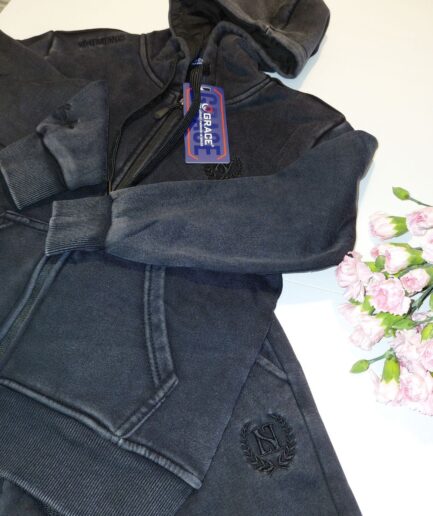 Grafitowy komplet dresowy z kapturem i spodniami, obok różowe goździki.